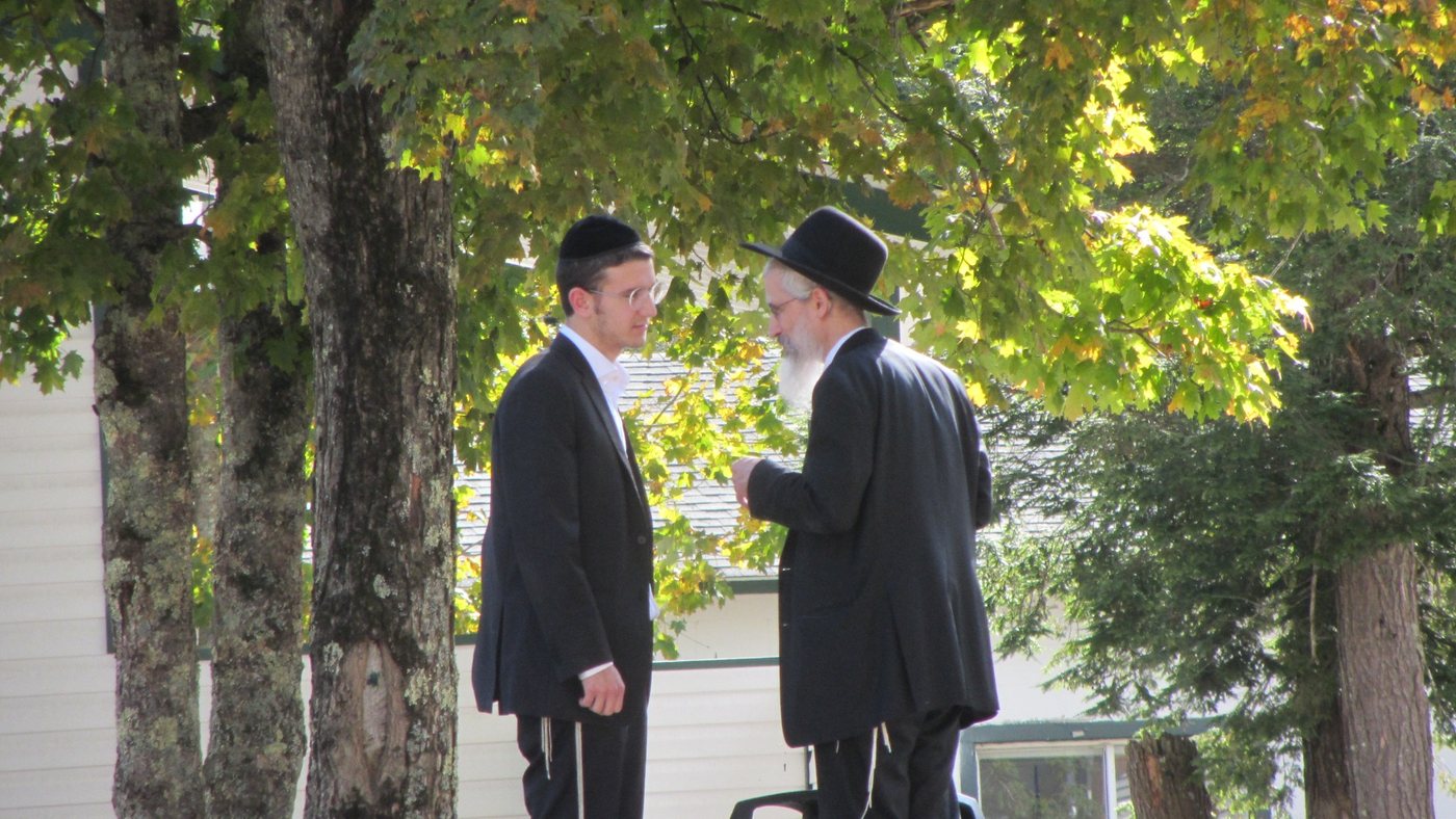 Rosh Yeshiva speaking with a talmid outdoors